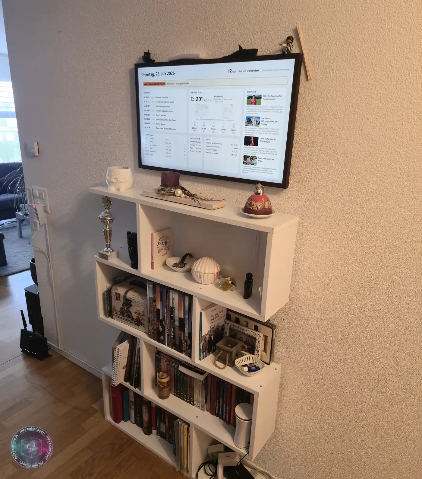 Foto des Frame-TV an der Flurwand über einem Bücherregal, auf dem Display läuft das Ambient-Dashboard im hellen Tag-Thema